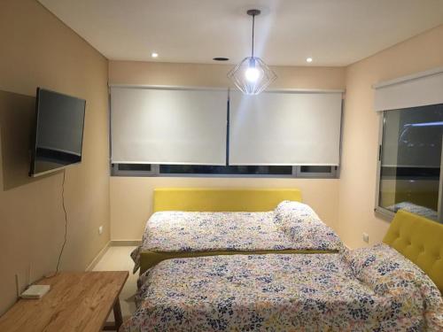 a bedroom with a bed and a table and window at la elegida in Mar Azul