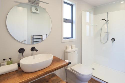 a white bathroom with a sink and a mirror at Bivouac - Lake Tekapo in Lake Tekapo