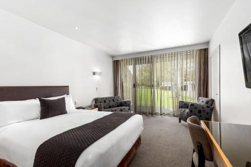 a hotel room with a bed and a large window at The Commodore in Mount Gambier