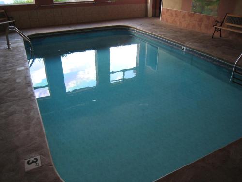 a swimming pool with blue water in a building at Days Inn by Wyndham Penticton Conference Centre in Penticton