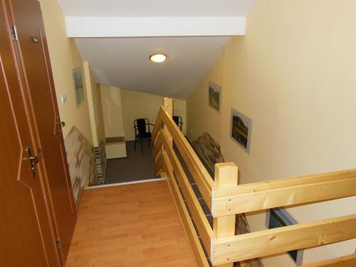 a hallway with a wooden staircase with a wooden railing at Penzión Pod Guglom in Mlynky 