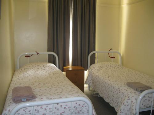 Habitación hospitalaria con 2 camas y ventana en Delegate Nurses Cottage, en Delegate