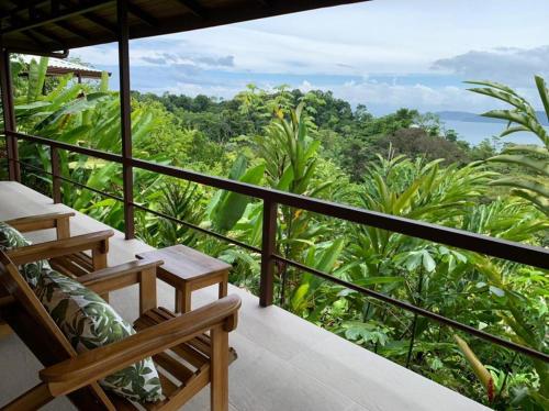a balcony with two chairs and a view of the forest at Drake Bay Greenleaf in Drake