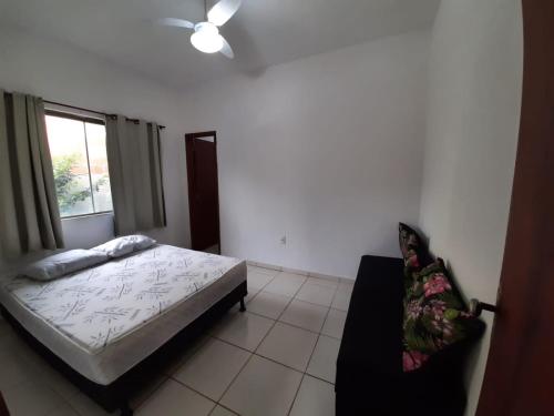 a bedroom with a bed and a window and a chair at Vivamar2 in Cabo Frio