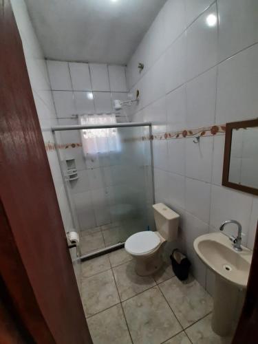 a bathroom with a shower and a toilet and a sink at Vivamar2 in Cabo Frio