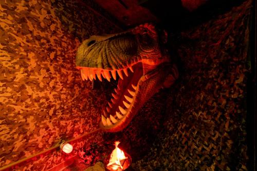 a dinosaur skeleton on the floor next to leaves at HOTEL ARTIA DINOSAUR GIFU -Adult Only in Rokujō