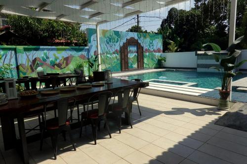 un patio con tavoli e sedie accanto a una piscina di Villapadu Desa a Kuala Terengganu