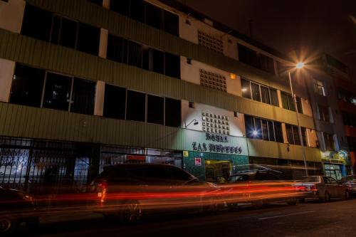 een auto die 's nachts langs een gebouw rijdt bij Hotel Las Mercedes in Trujillo