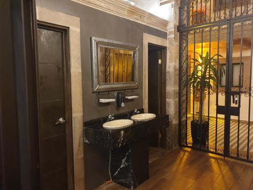 a bathroom with two sinks and a mirror at Hotel Don Carlos in Morelia