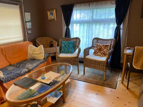 a living room with a couch and chairs and a table at Guest House Mitsuka in Shishikui