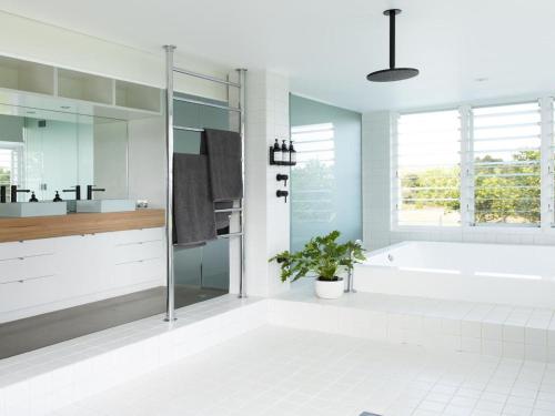 a white bathroom with a tub and a sink at Amileka - luxury 25 acre estate with pool in Federal