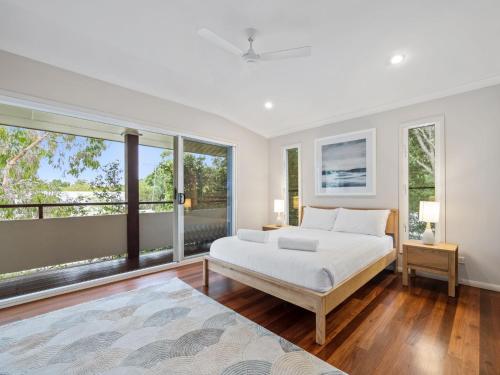Un dormitorio con una cama y una ventana grande. en Banksia Beach House by Discover Stradbroke, en Point Lookout