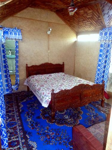 a bedroom with a bed in a room with blue carpet at Raja's Palace Houseboat - Kashmir in Srinagar