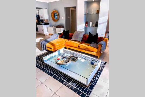 a living room with two couches and a coffee table at Summerstrand Boutique Beach Apartment in Summerstrand