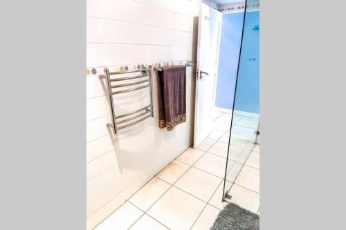 y baño con cabina de ducha de cristal y toallas. en Summerstrand Boutique Beach Apartment, en Summerstrand
