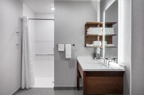 a white bathroom with a sink and a shower at Staybridge Suites - Iowa City - Coralville, an IHG Hotel in Coralville