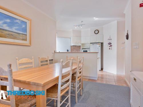 a kitchen and dining room with a wooden table and chairs at Kaella in Thredbo