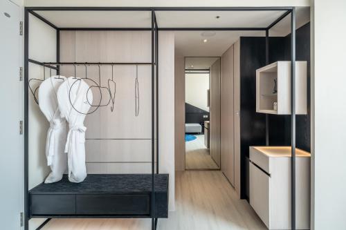 a walk in closet with a glass door and white coats at The Place Taichung in Taichung