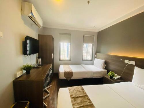 クアラルンプールにあるAsia Like Boutique Hotelのベッド2台とテレビがあるホテルの部屋