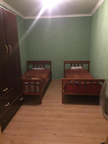 Dos camas en una habitación con paredes verdes. en lukyhome, en Tiflis