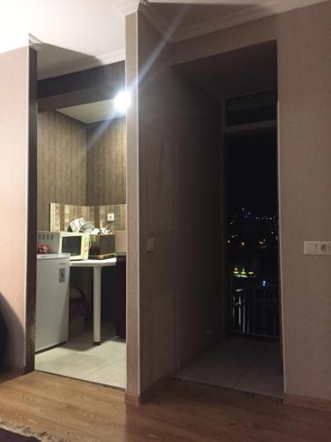 una puerta abierta a una cocina con una mesa y un escritorio en lukyhome, en Tiflis