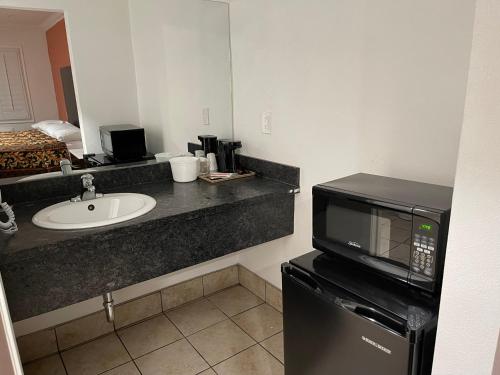 a kitchen with a sink and a microwave at The Oaks Motel in Oakland