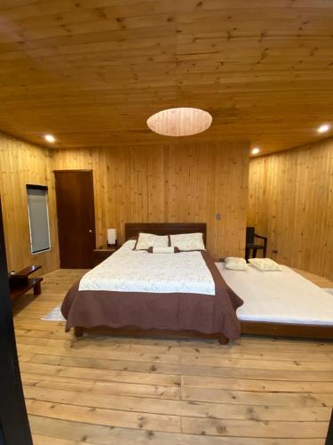 a bedroom with a large bed in a room with wooden walls at Glamping/BBQ Susa Cun in Susa