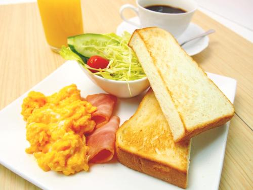 a plate of food with eggs toast and a cup of coffee at Hotel Lotus Mito-Adult Only in Mito