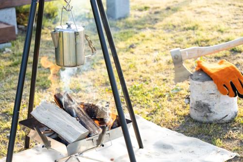 a grill with a tea kettle and a fire at agris FURANO 01 FARM GUEST HOUSE in Nunoppe