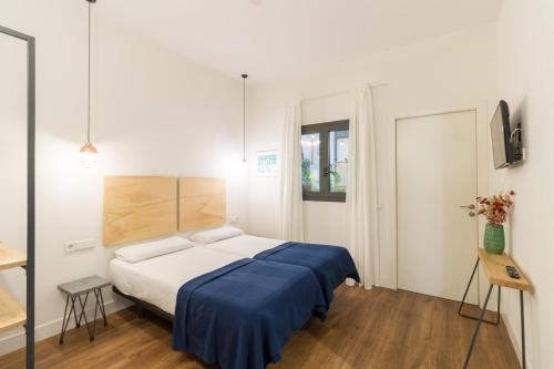 a bedroom with a bed with a blue blanket at Magatzem 128 in Barcelona