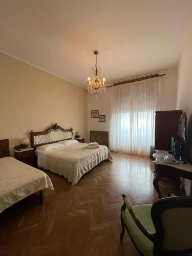 a bedroom with two beds and a chandelier at Villa Sara in Taormina