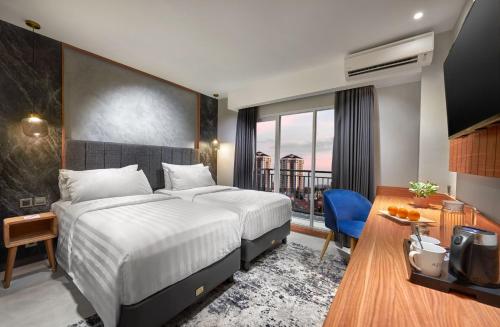 a hotel room with a bed and a balcony at Aston Inn Jemursari in Surabaya