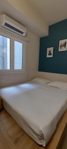 a large white bed in a room with a window at The Convo Athens Riviera in Athens
