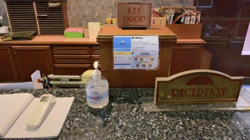 an office counter with a bottle of water and a sign at Kawan Hotel in Sibu
