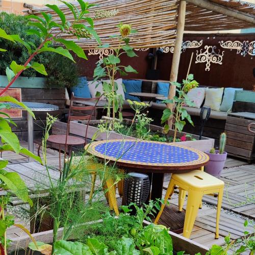 a patio with a table and chairs in a garden at Sud Hôtel Restaurant in Bastia