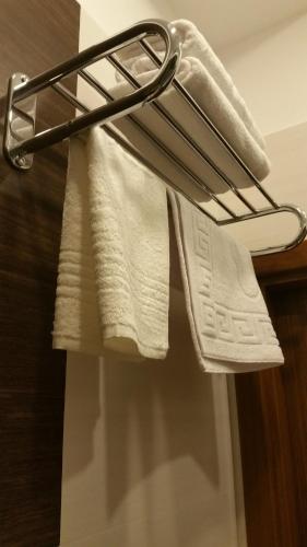 a towel rack with white towels on it in a bathroom at Baku Sea View Hotel in Baku