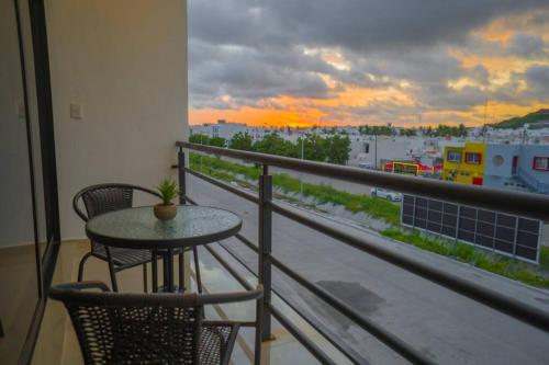 a table and chairs on a balcony with a view of a city at Departamento Atlántico Alberca y Casa Club in Mazatlán