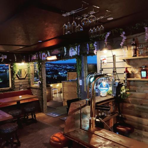 a bar with a view of a city at night at Serendipity House in Derry Londonderry