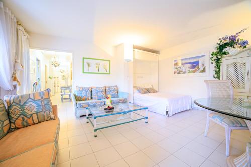 un salon avec un canapé et un lit dans l'établissement Appartement Les Allées, à Cannes