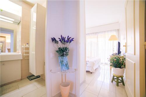 un salon avec un vase de fleurs sur une table dans l'établissement Appartement Les Allées, à Cannes