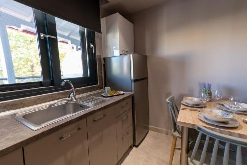 a kitchen with a sink and a refrigerator at Maltinas Apartments in Hanioti