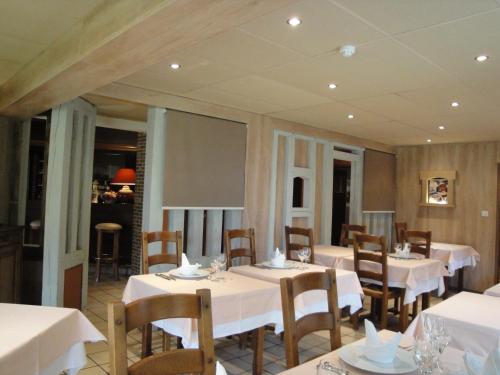 a dining room with white tables and chairs at Hotel Le Drakkar in Pont-Audemer