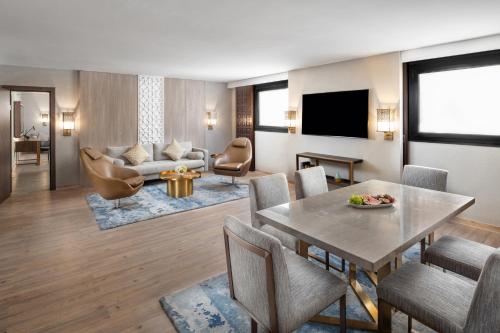 a living room with a table and chairs and a television at Makarem Ajyad Makkah Hotel in Makkah