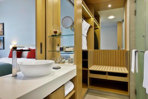 a bathroom with a white sink and a shower at Avani Ibn Battuta Dubai Hotel in Dubai