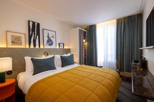 Giường trong phòng chung tại Hotel Dadou Paris