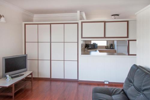 a living room with a large white wall at Holiday Surf Hotel (with full kitchen) in Honolulu