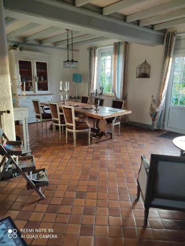 a living room with a wooden table and chairs at chambre au mont scolan in Montgardon