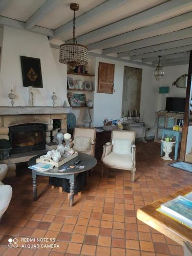 a living room with a table and a fireplace at chambre au mont scolan in Montgardon