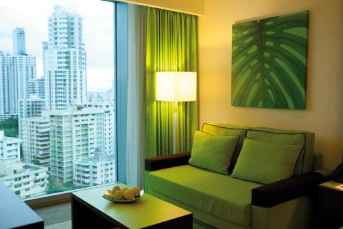 a living room with a couch and a large window at Riu Plaza Panamá in Panama City