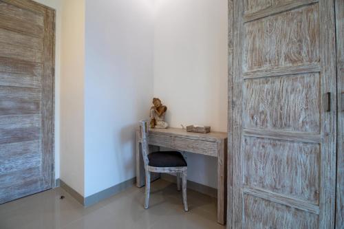 a wooden desk with a chair next to a door at Sayang Sanur Duplex in Sanur
